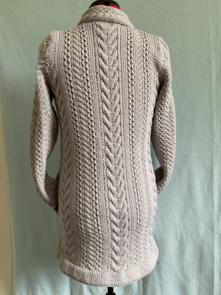 Back view of ladies knitted biker style coatigan with Aran stitches