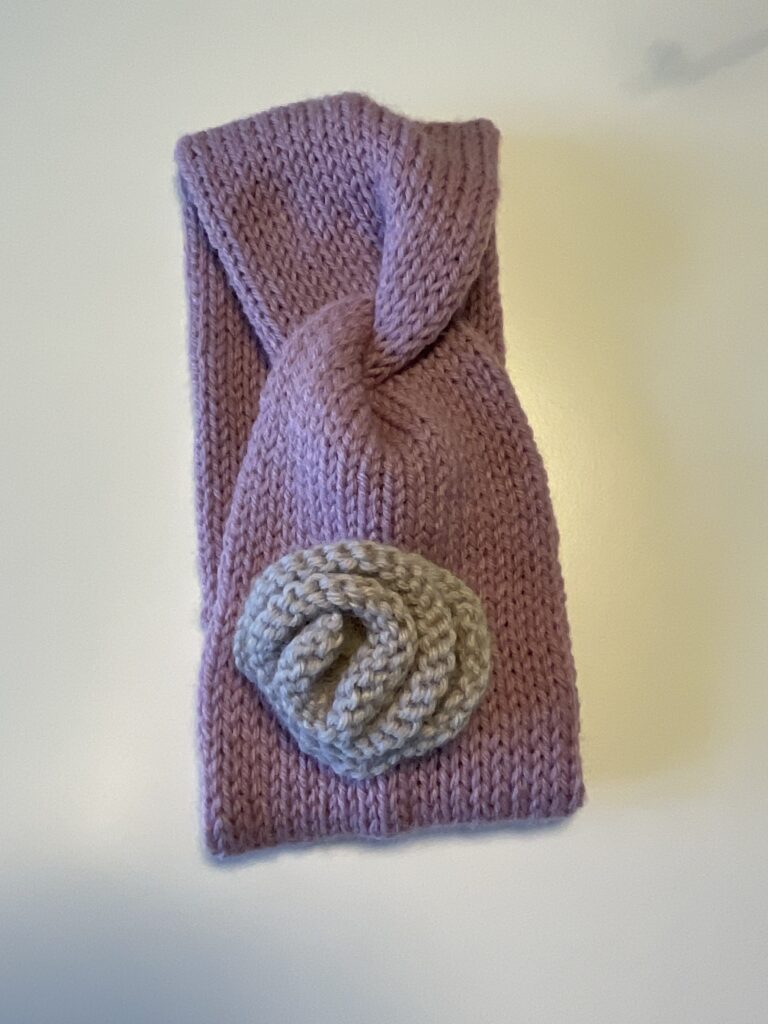 Knitted headband with contrast knitted rose