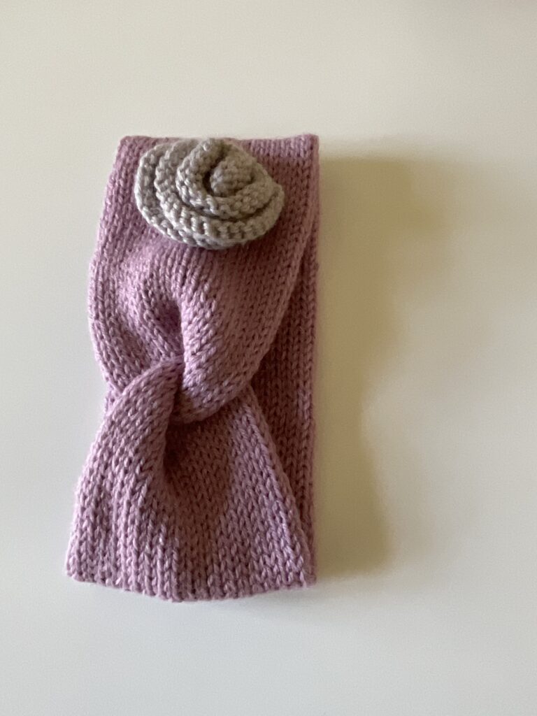 Knitted headband with contrast knitted rose.